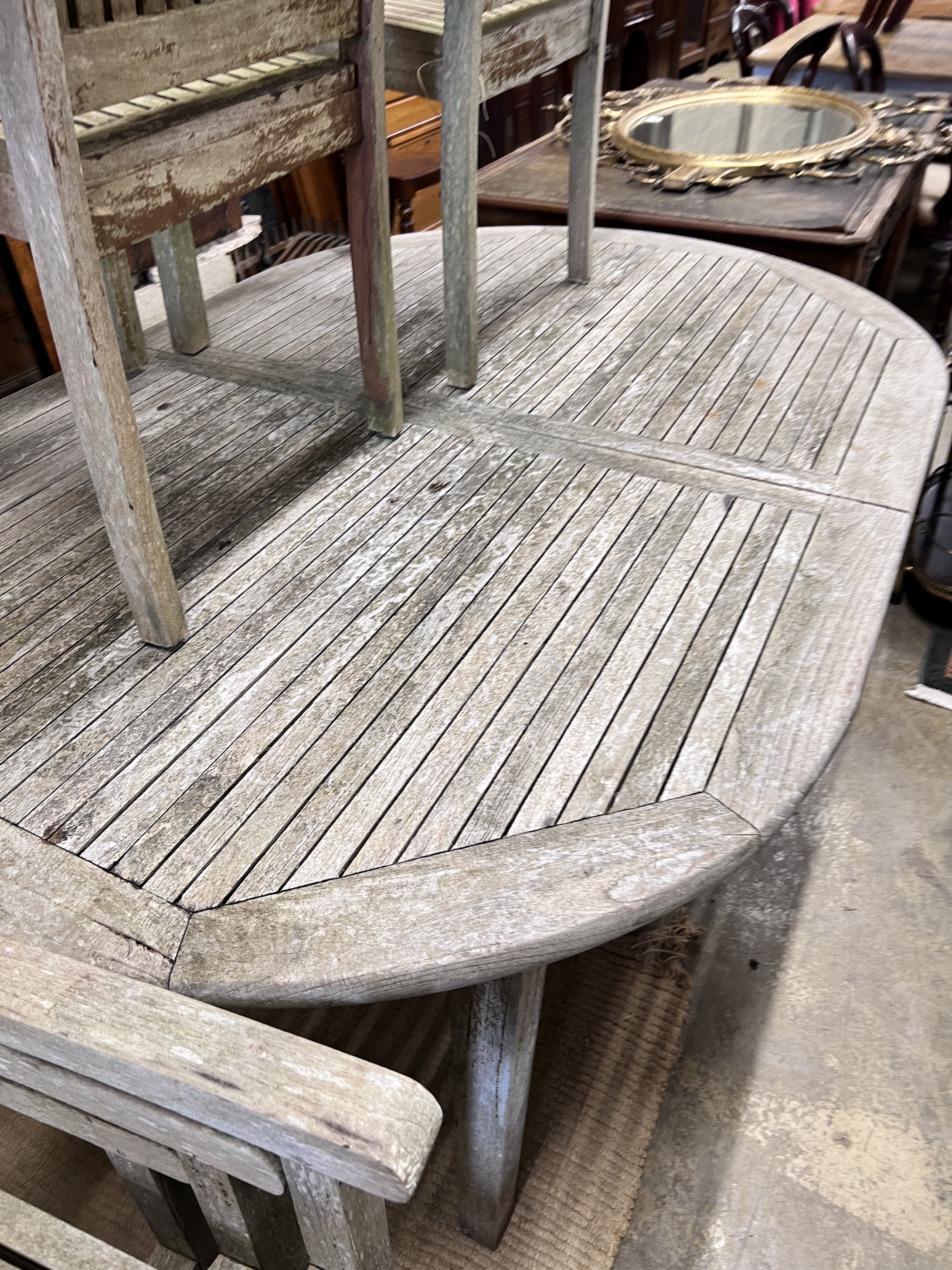 A Hard Woodstock Ltd. weathered teak extending garden table and eight matching stacking chairs